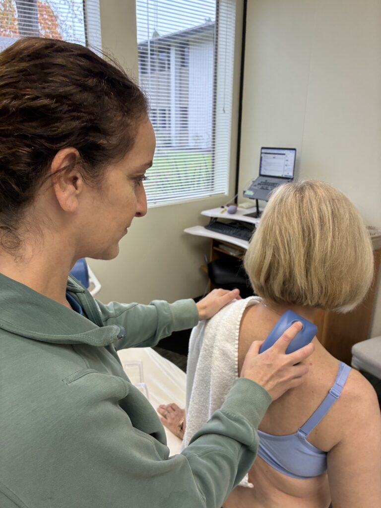 Physical Therapist performing Shockwave on female patient